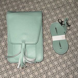 Light green/ blue bag with attachable crossbody strap.